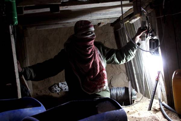 Un contrabbandiere palestinese in uno delle centinaia di tunnel che collegano l'Egitto a Gaza