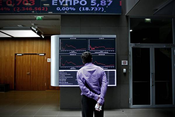 Un impiegato osserva l'andamento della Borsa di Atene