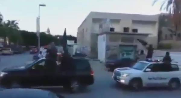 Ansar al Sharia militants in Derna aboard armed pickup trucks waving ISIS flags and hailing al Baghdadi in a shot from a video