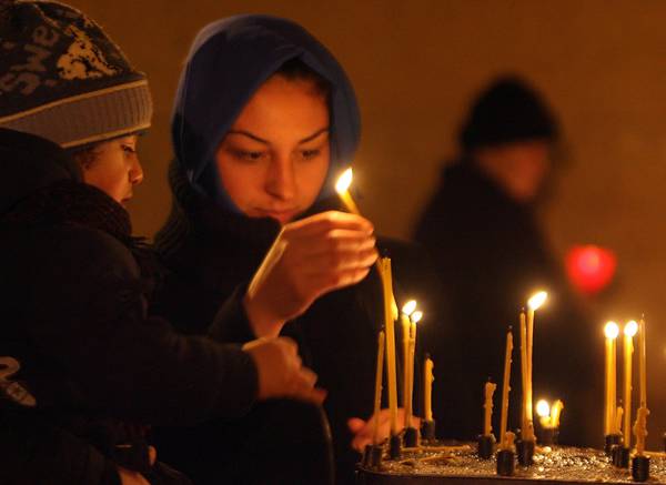 Fedeli greco- ortodossi accendono lumi di preghiera