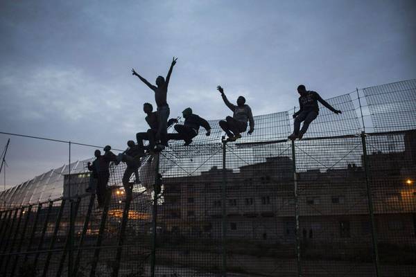 Migranti  superano la barriera di Melilla in una foto di Santiago Palacios che ha vinto il Premio nazionale di fotogiornalismo del 2015