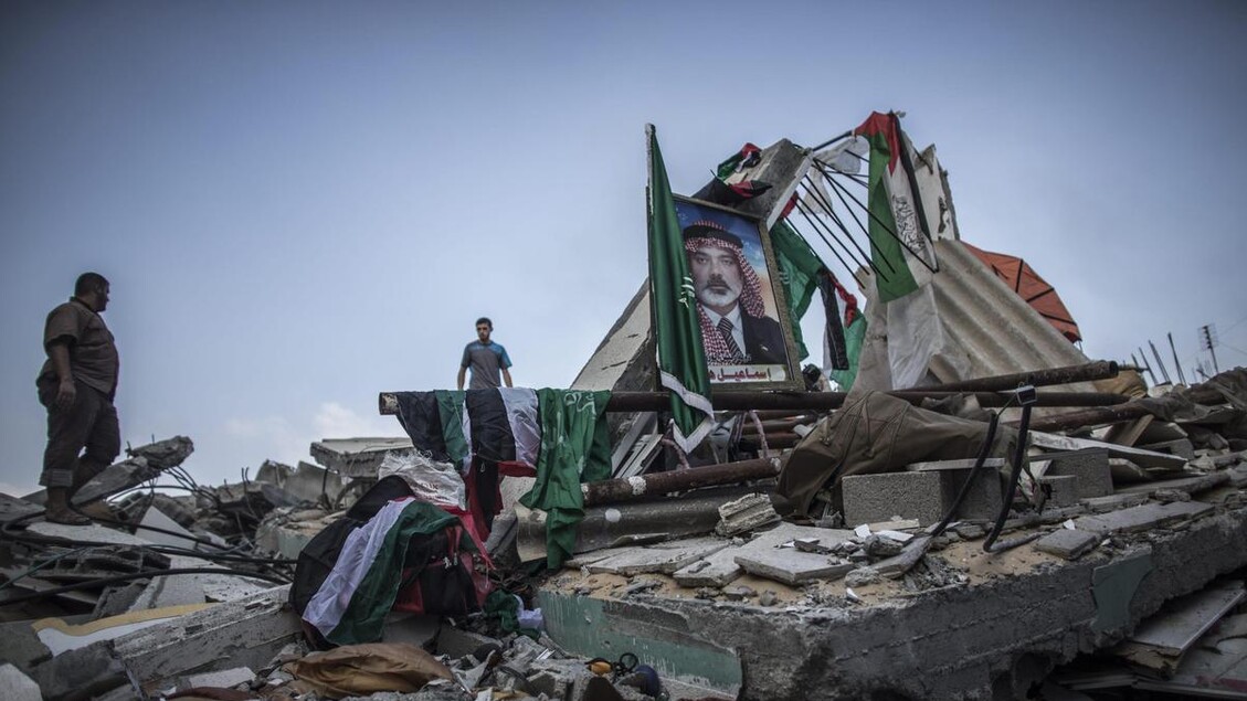 Un quadro con il ritratto del leader di Hamas Ismail Haniye in mezzo ai resti della sua casa nel campo di Shati distrutta nella notte da un raid israeliano - RIPRODUZIONE RISERVATA