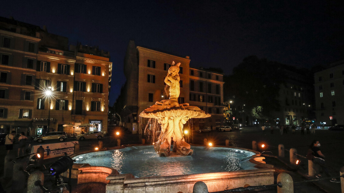 The Tritone 's Fountain is illuminated in orange - ALL RIGHTS RESERVED