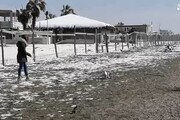 Romani 'in vacanza', neve sulla spiaggia di Ostia