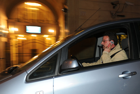un uomo telefona mentre guida in una foto d'archivio © ANSA