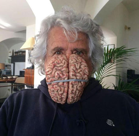 Beppe Grillo con una mascherina a forma di cervello © ANSA