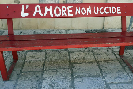 Una panchina rossa con la scritta "L'amore non uccide"
