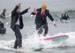 Gary Crane, left, of Long Beach cheers on Dave Granoff, of Newport Beach, who dressed as a flag-waving President Donald Trump as they surf with approximately 100 other surfers wearing wacky Halloween costumes on Saturday, Oct. 28, 2017 © Ansa