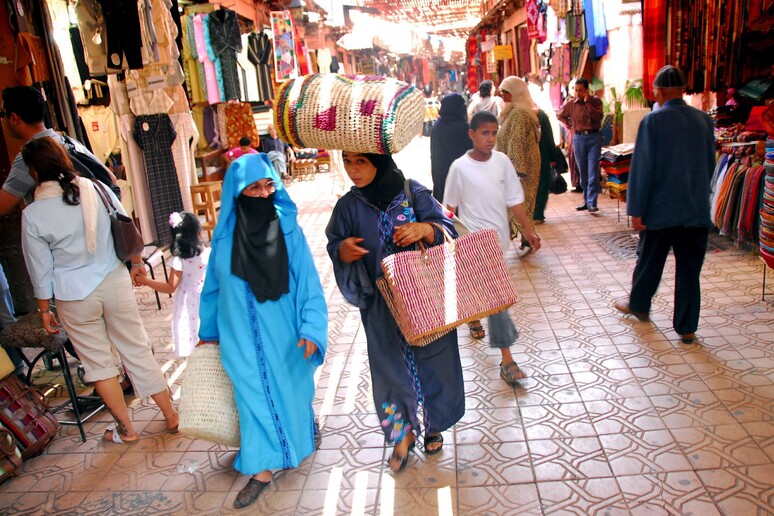 Moroccan women carry good they bought at Souk Semmarin  in Marrakech [ARCHIVE MATERIAL 20080608 ] -     RIPRODUZIONE RISERVATA