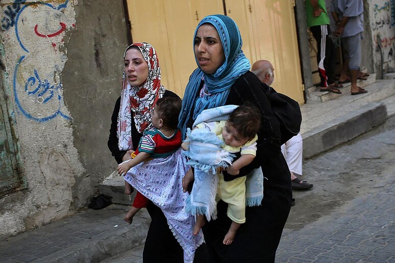 Donne di Gaza in fuga insieme ai loro bambini © ANSA/EPA