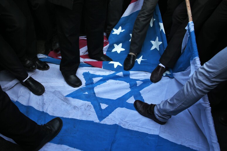 Manifestanti iraniani calpestano bandiera di Israele © ANSA/AP
