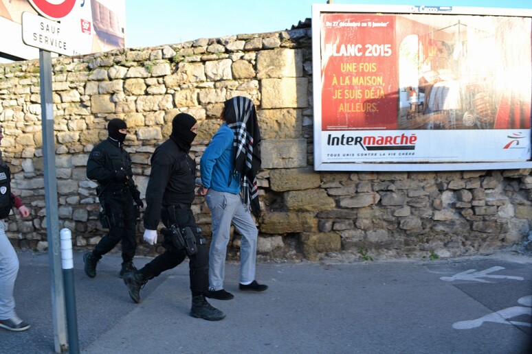 Poliziotti incappucciati impegnati in una operazione anti-terrorismo nel sud della Francia © ANSA/AP