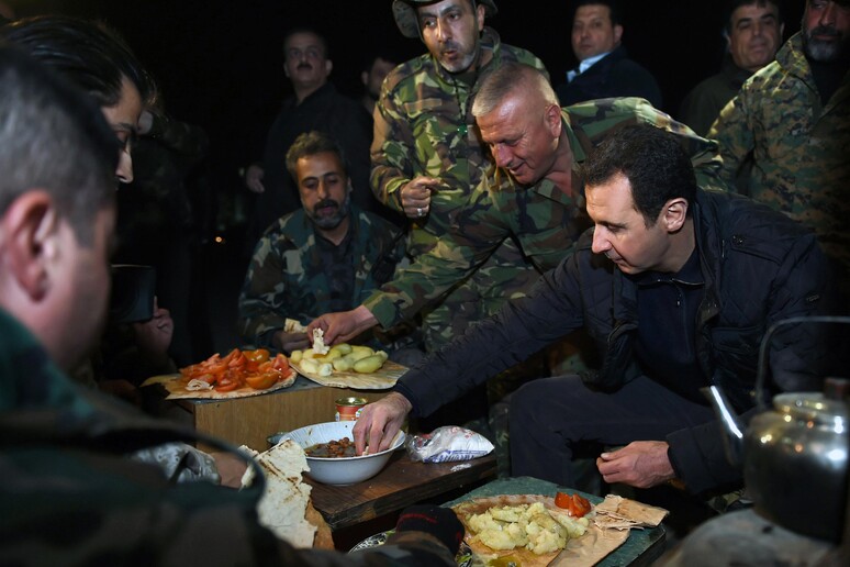 Bashar Assad, shares a meal with Syrian troops during his visit on the front line © ANSA/AP