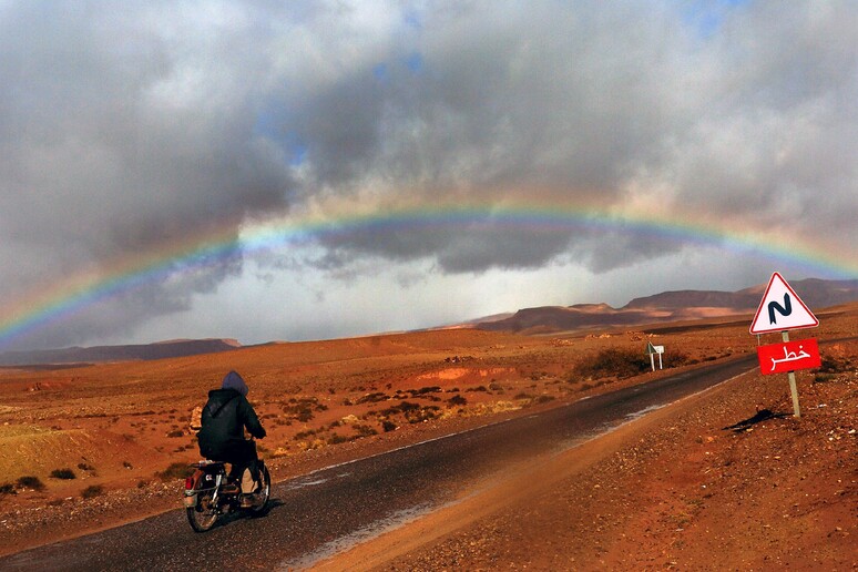 Un uomo in motocicletta attraversa il deserto del Sahara vicino a  Ouarzazate -     RIPRODUZIONE RISERVATA