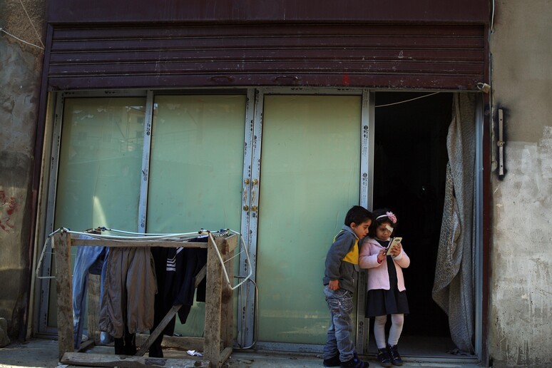 Due fratellini di Homes davanti alla loro casa di fortuna a Tripoli, in Libano © ANSA/AP