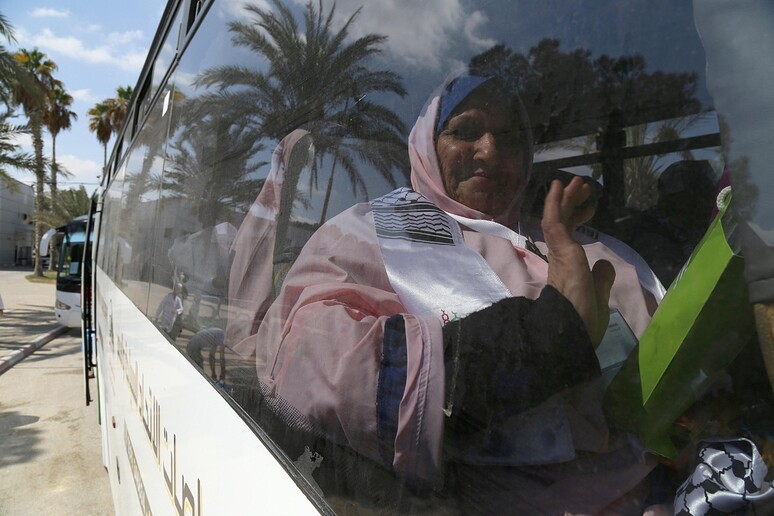 Una donna saluta i parenti dal bus con cui attraverserà il valico di Rafah per recarsi in pellegrinaggio alla Mecca. © ANSA/EPA