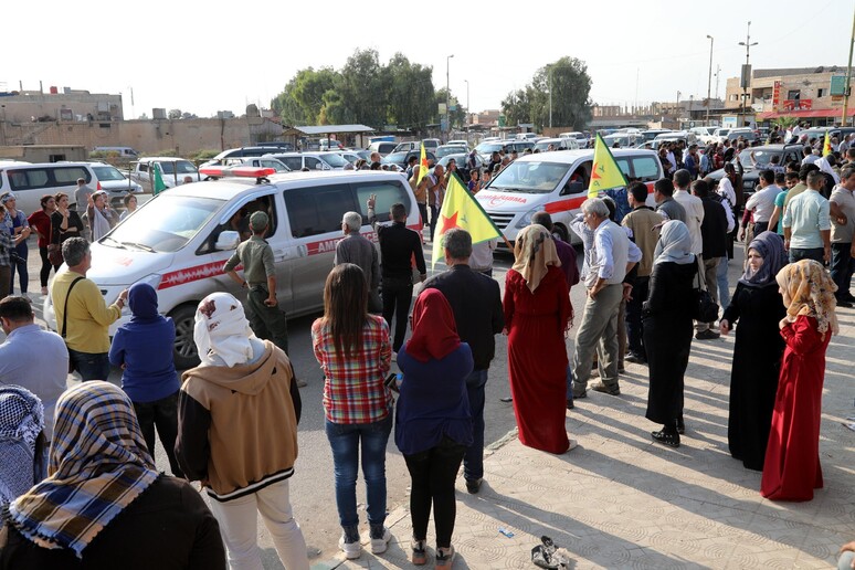 Civili curdi guardano passare ambulanze con feriti dell 'offensiva turca in Siria © ANSA/EPA