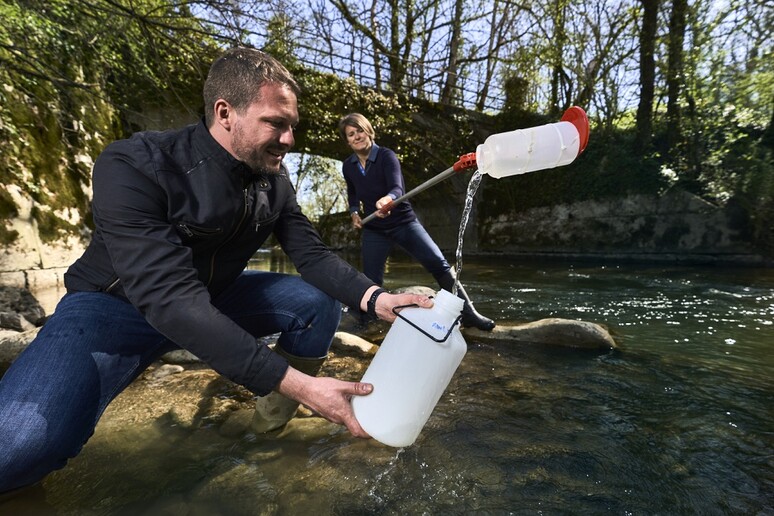 Gli esperti di protezione ambientale del Cern raccolgono l 'acqua di un fiume da analizzare (fonte: CERN) - RIPRODUZIONE RISERVATA