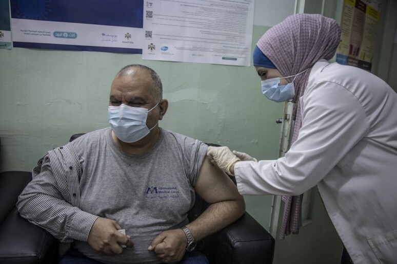 Un medico somministra il vaccino contro il Covid-19 ad un uomo all 'ospedale di Irbid in Giordania -     RIPRODUZIONE RISERVATA