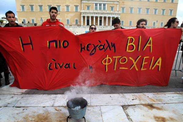 Students hold a banner reading 'The worse violence is poverty' in front of the Greek Parliament during a demonstration in central Athens