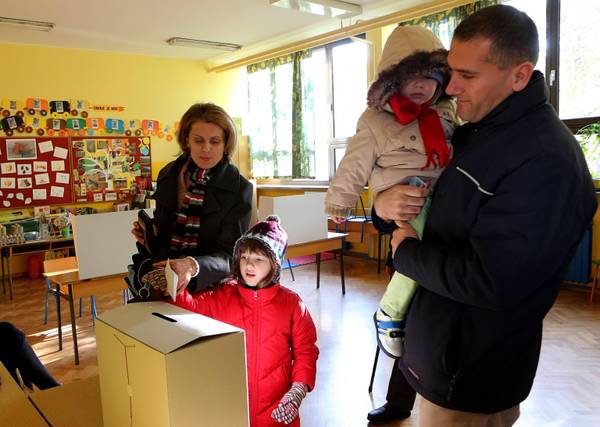 A young family casts their vote at a polling station in Zagreb during the referendum which is asking Croats to constitutionally define marriage as a union between a man and woman