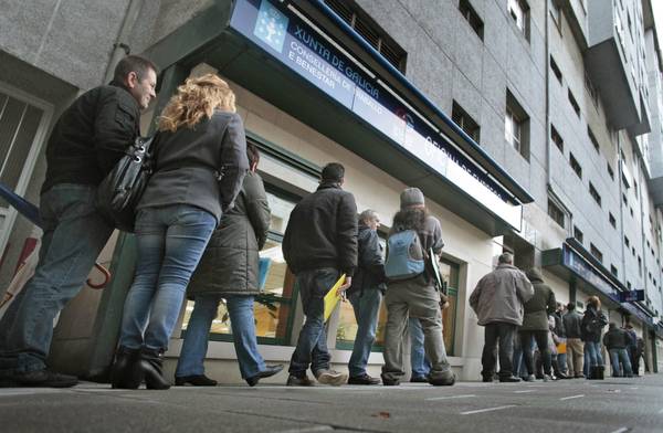 Dozens of people queue up at an Unemployment Office at La Coruna, northwestern Spain