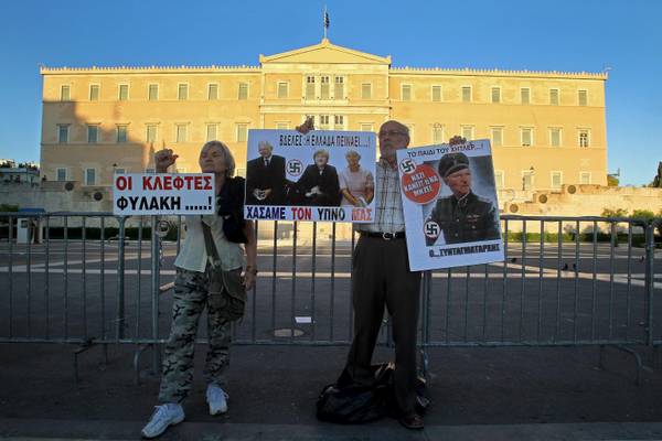 Pensioner hold placards during a rally outside the Greek Parliament in Athens, Greece,  31 May 2013
