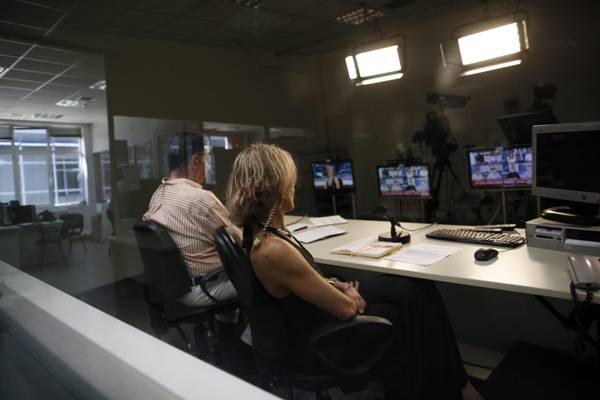 Journalists sit in a studio of the state broadcaster ERT headquarters in Athens