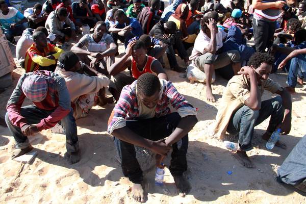 Migrants from sub-Saharan Africa rest after being rescued by the Libyan coastguard when  their boat sank on October 2, 2014