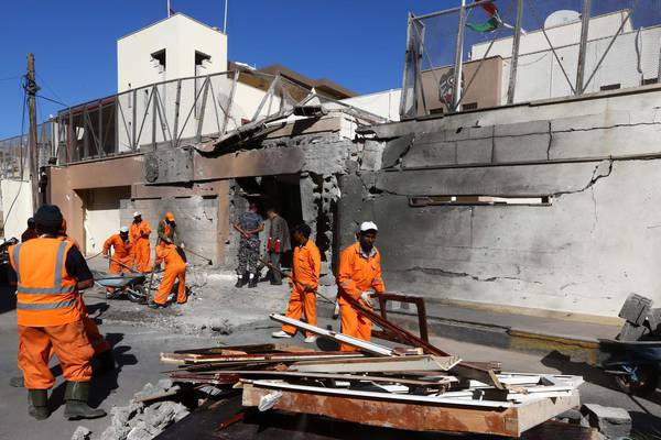 Workers clean outside the damaged building of the UAE embassy that was targeted by car bomb  explosion, in Tripoli.