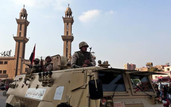 Members of the Egyptian army maintain a guard from the top of an armoured personnel  carrier, Matareya Square, Cairo, Egypt, 28 November 2014