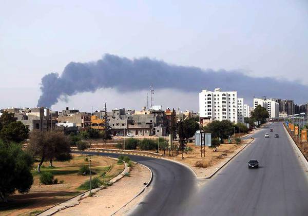 Black smoke billows from a fuel storage depot, near the airport in Tripoli, Libya, after it was hit by a rocket fire