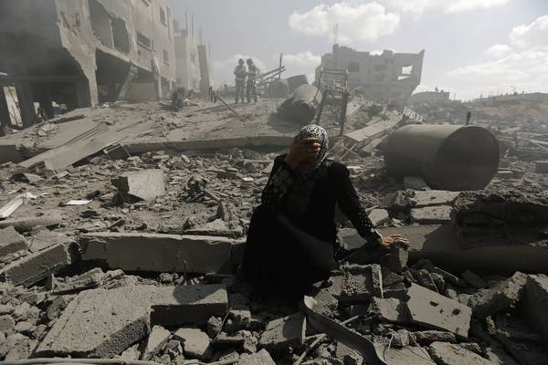 Una donna tra le macerie di un quartiere distrutto a Gaza - agosto 2014 (Oxfam)