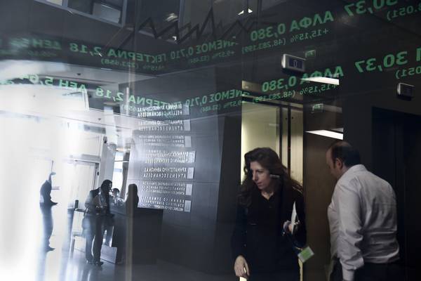 Employees walk under the  screens of the Athen's Stock Exchange