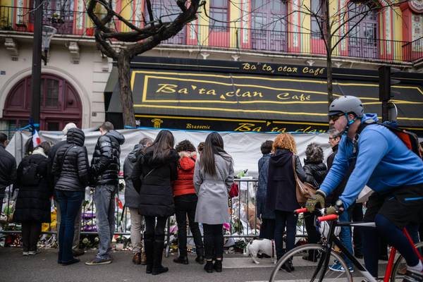 People gather in front of the Bataclan Theater to pay tribute to the victims of the 13 November attacks, in Paris