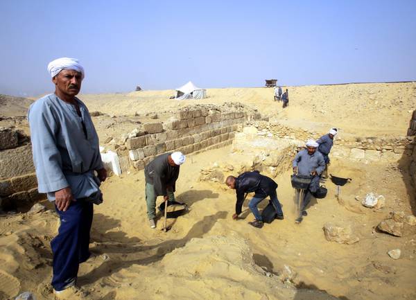 Egyptian excavation workers labor outside a tomb on the  Giza platea
