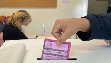 Un elettore infila la scheda in un'urna in una foto d'archivio (ANSA)