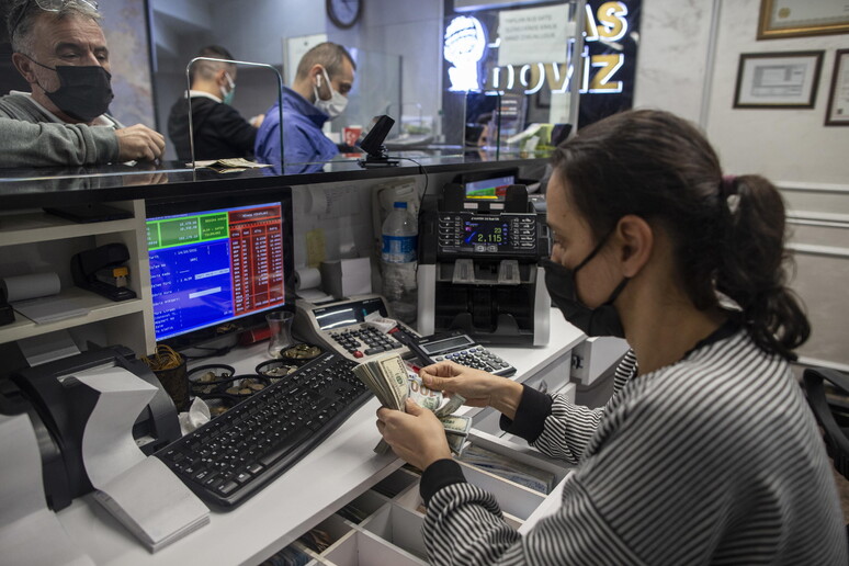 Turchi cambiano soldi in un ufficio di cambio a Istanbul © ANSA/EPA