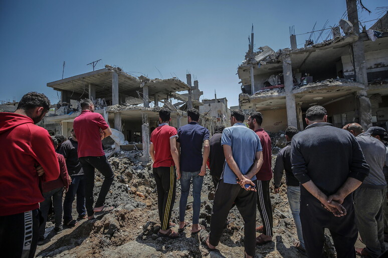 Palestinesi di fronte alle loro case distrutte dai raid israeliani a Beit Hanun nel nord della Striscia di Gaza © ANSA/EPA