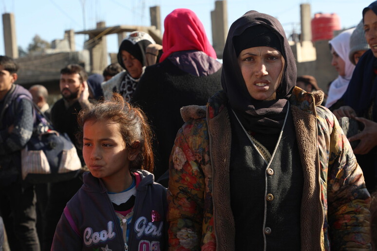 Curdi siriani che hanno lasciato le loro case dopo gli scontri con i miliziani dell 'Isis arrivano al posto di blocco delle Forze Democratiche Siriane (SDF) nel quartiere di Gweiran a Hasake © ANSA/EPA